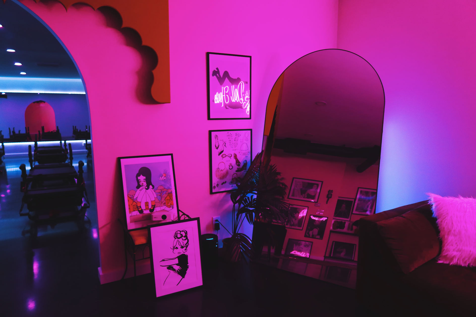 Studio lounge with arched wall opening, mirror, and curated framed artwork